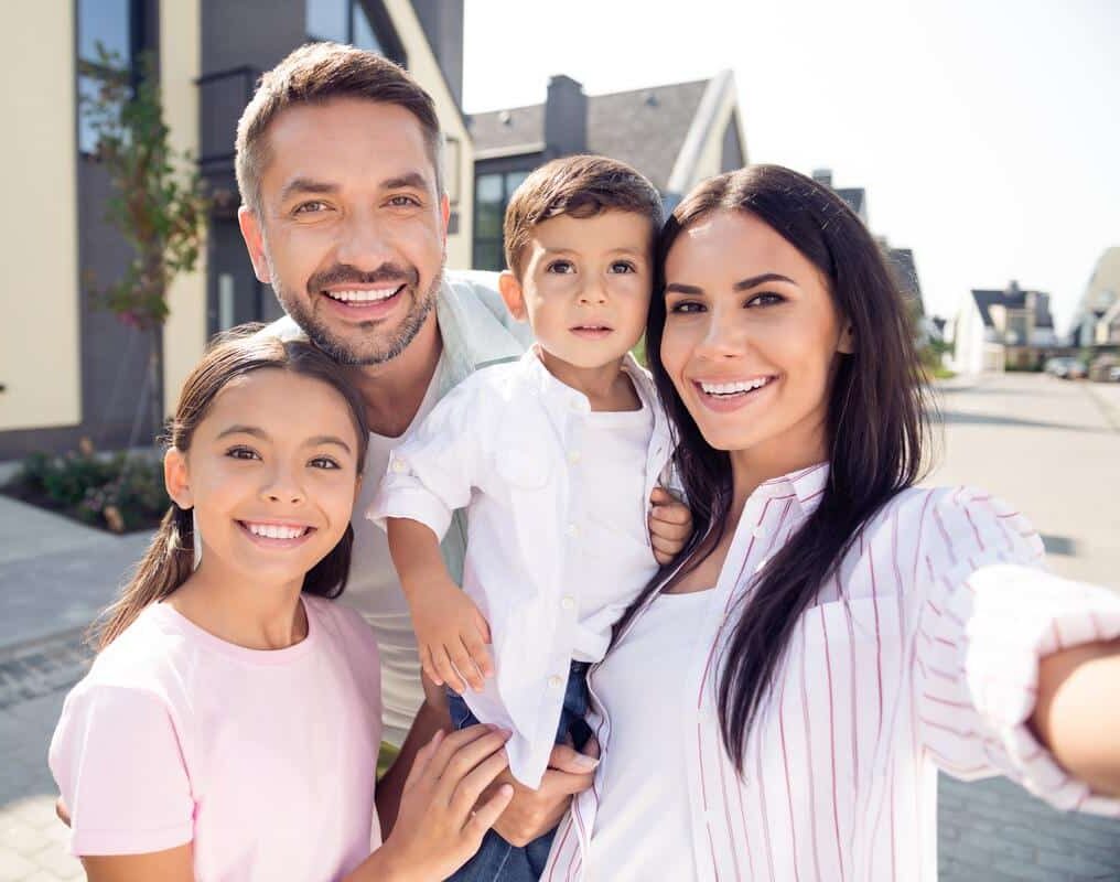 happy young family healthy smiles outside neighborhood children daughter son parents