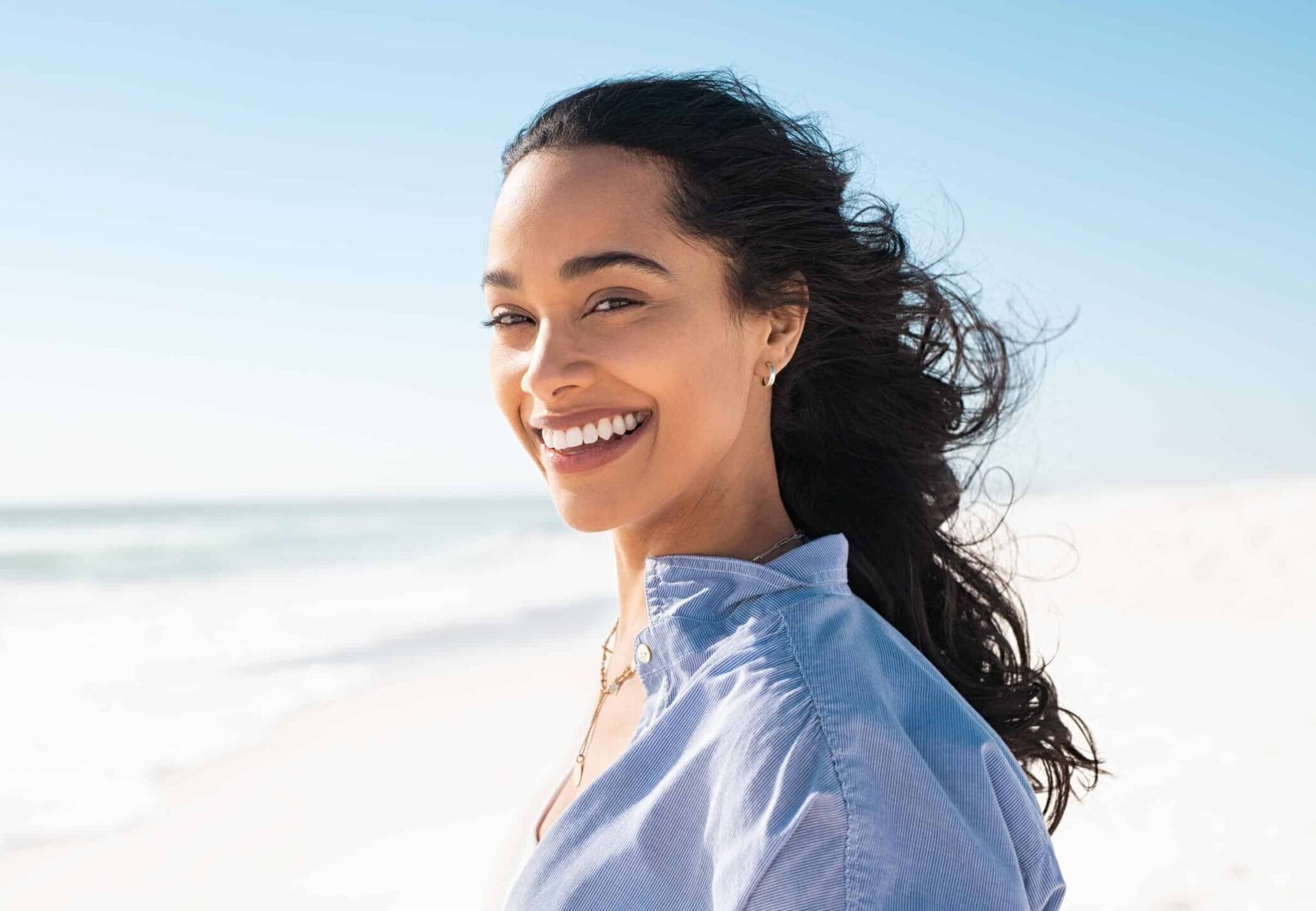beautiful woman on beach smiling with perfect teeth