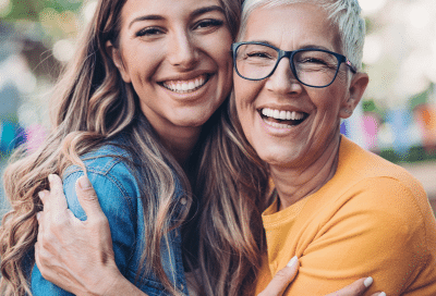 Mother and daughter hugging and smiling about adult orthodontics