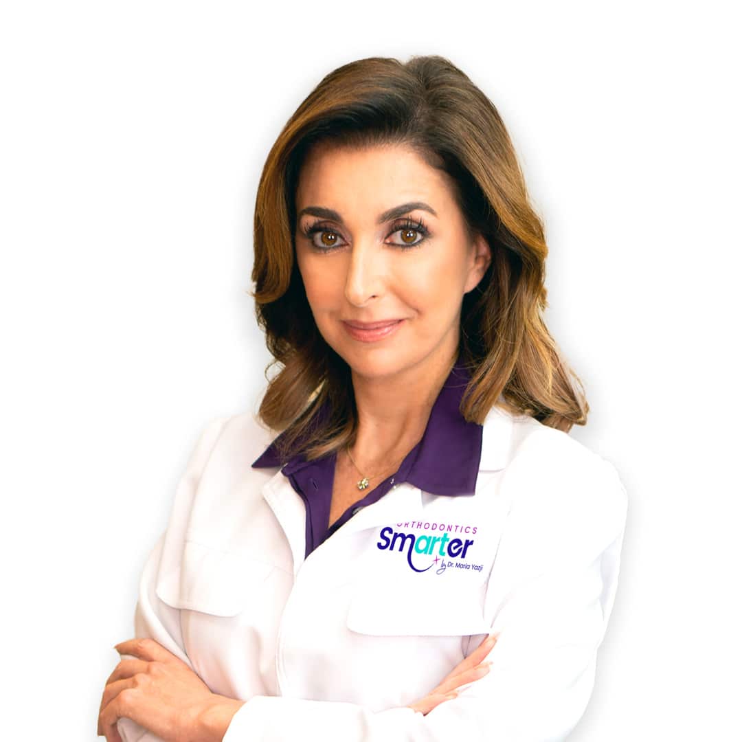 Groundbreaking orthodontist Dr. Maria Yazji in her white coat with arms crossed