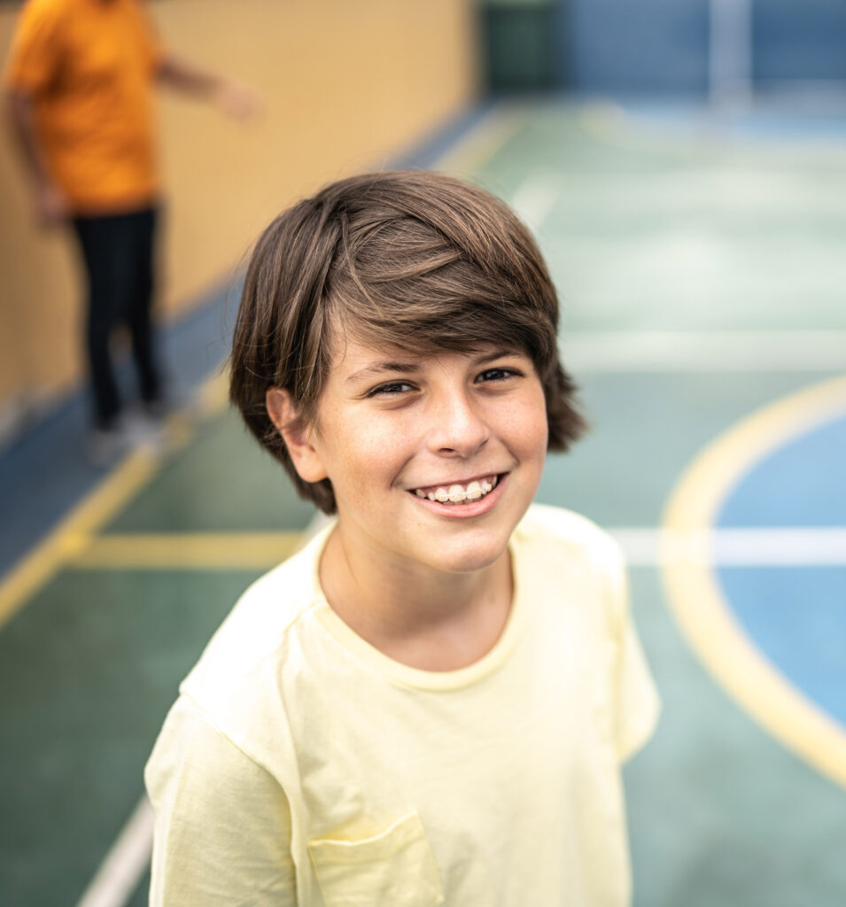 Portrait of a boy at a sports court with braces