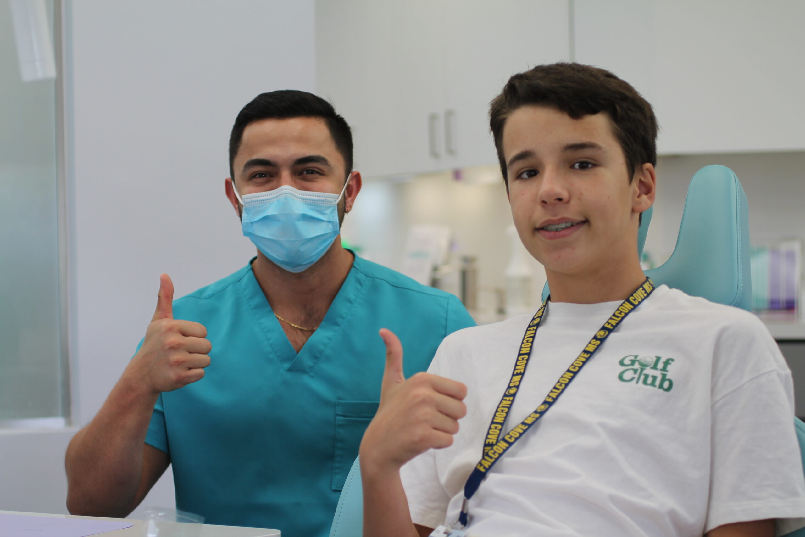 a teen patient with braces giving a thumbs up with a nurse